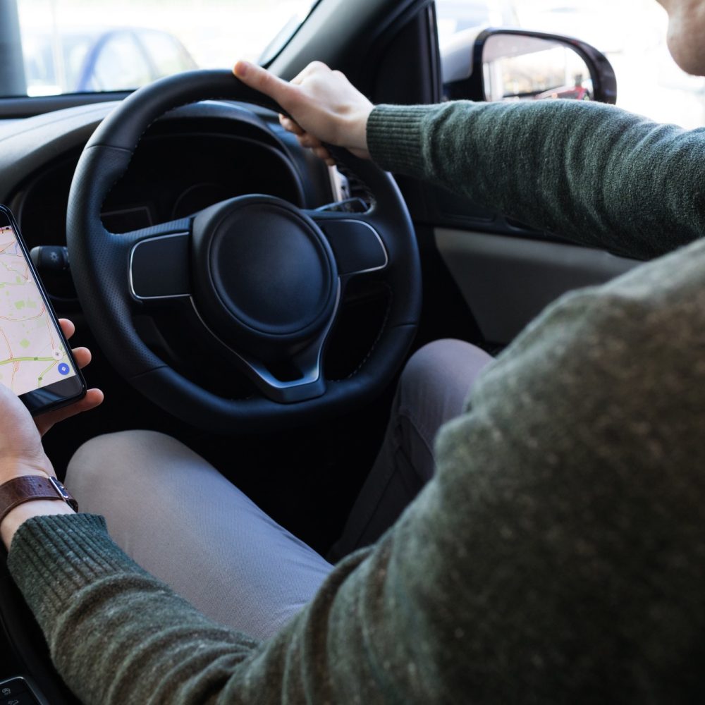 man-using-smartphone-while-driving-car.jpg